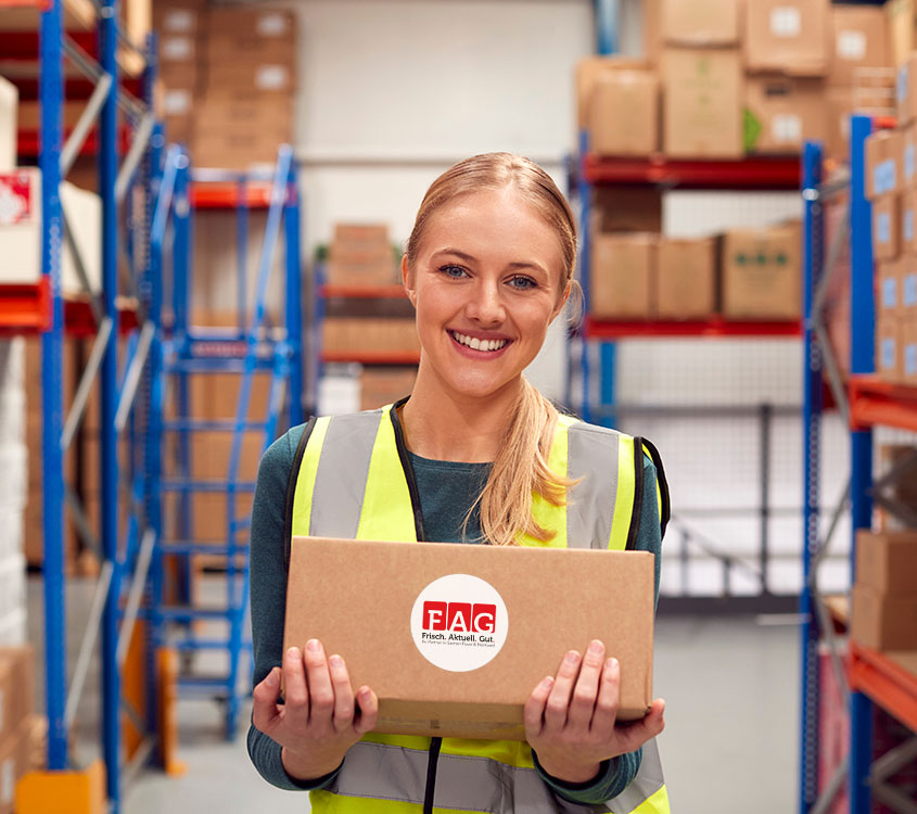 Portrait Of Female Worker Holding Box Inside Warehouse